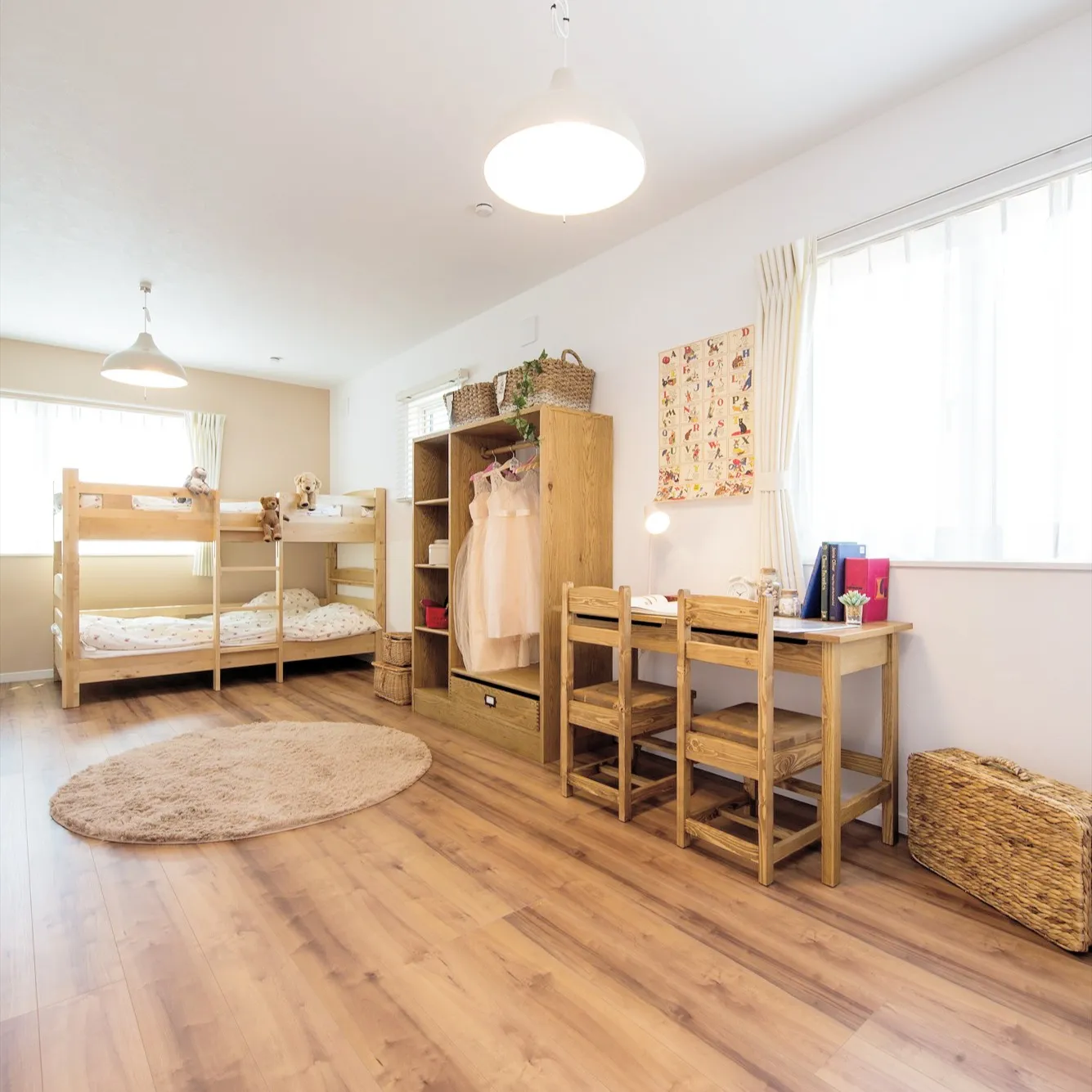 この子供部屋は、自然な白さの壁に囲まれ、素朴な木製の家具が温...